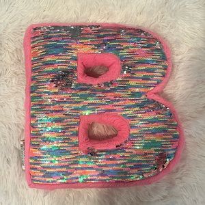 It’s a B, sparkly sequence, pink pillow
